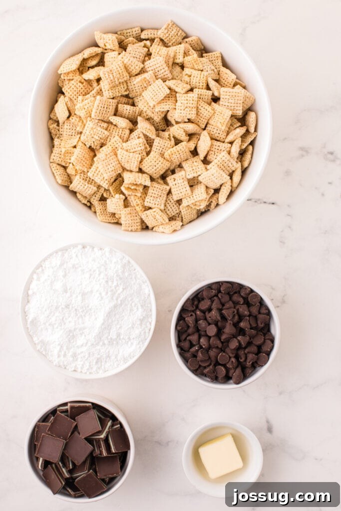 Overhead view of bowls filled with Rice Chex cereal, powdered sugar, chocolate chips, chopped Andes mints, and butter on a marble surface.