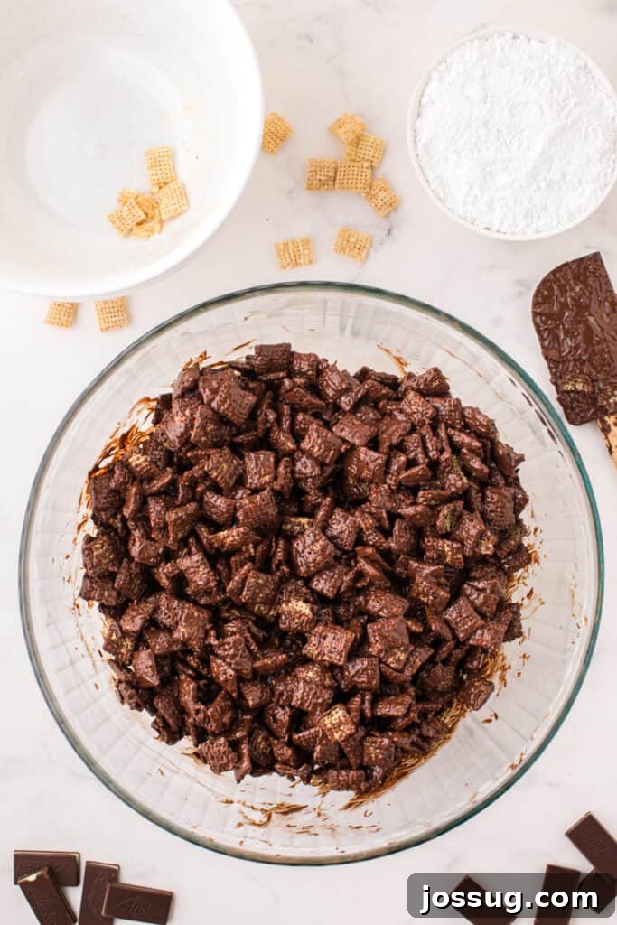 Rice Chex cereal fully coated in melted chocolate inside a large mixing bowl.