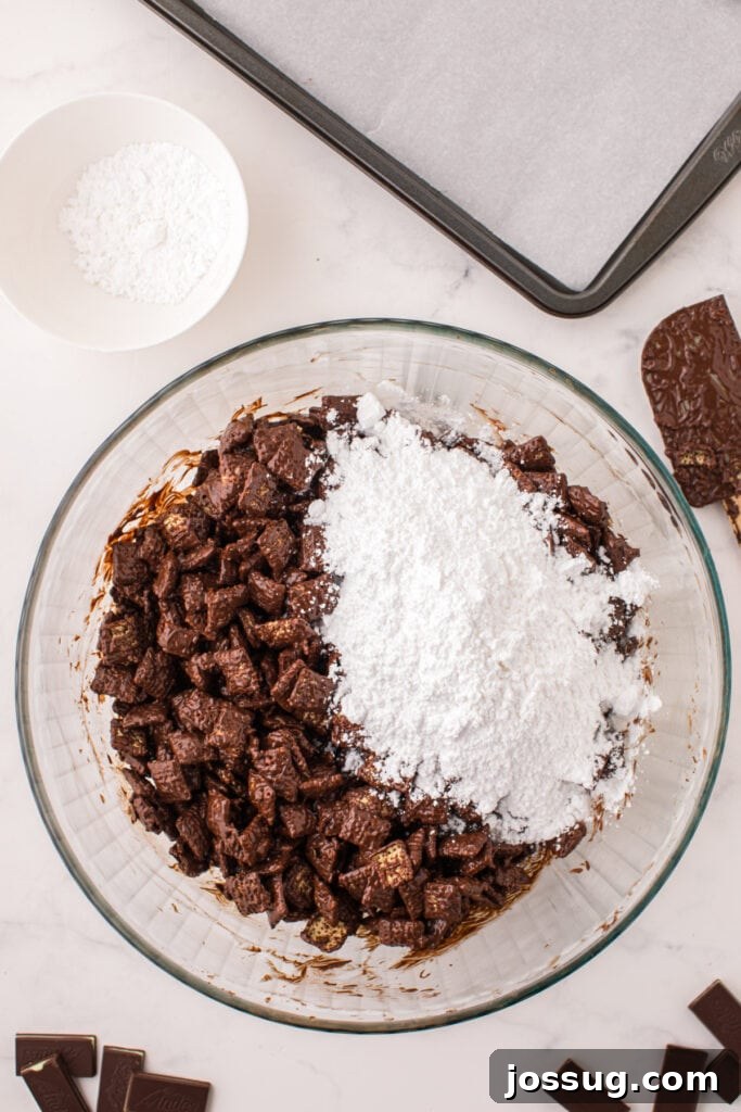 Powdered sugar added on top of chocolate coated cereal in a mixing bowl before shaking to coat.