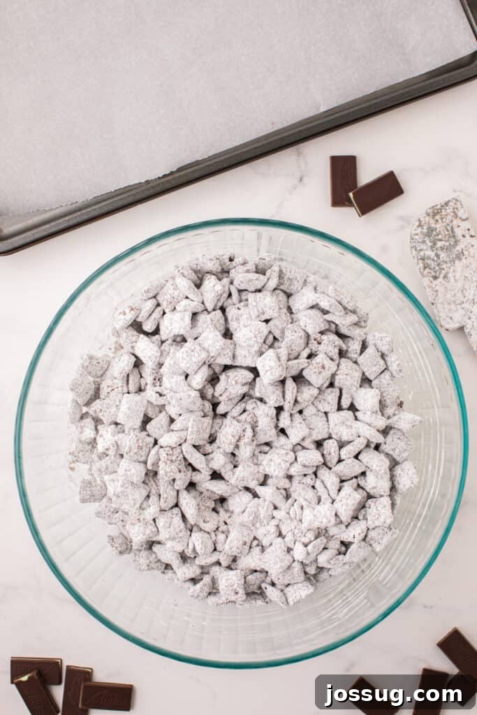 Fully coated Thin Mint Muddy Buddies in a large bowl before spreading on a baking sheet.