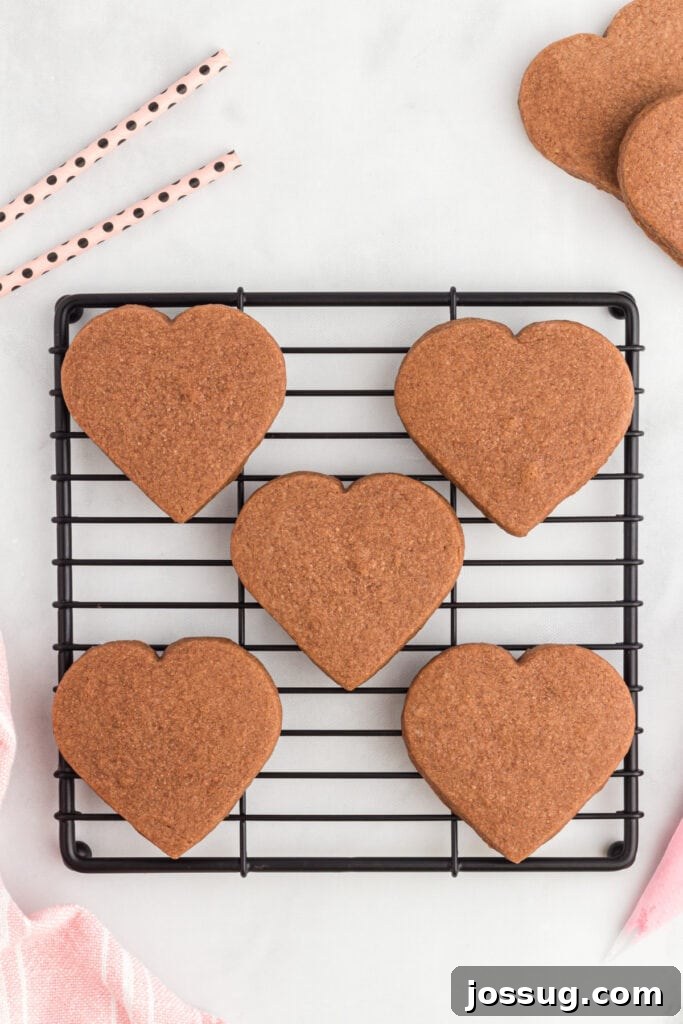 Cooled heart-shaped chocolate cookies on a wire rack.