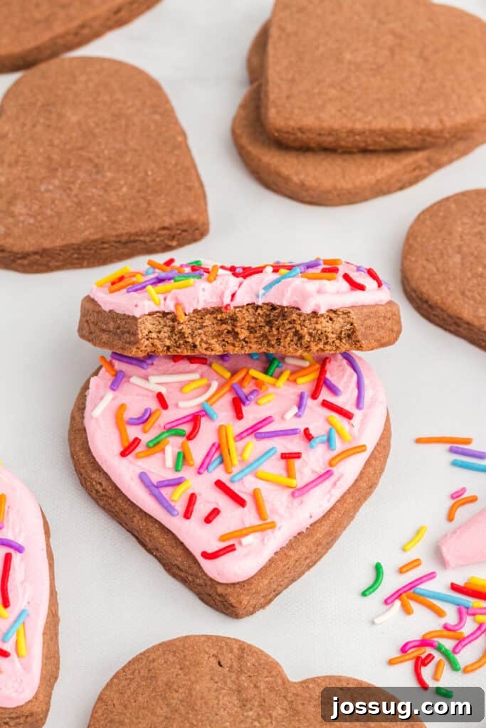 Frosted heart-shaped chocolate cookie with a bite taken out.
