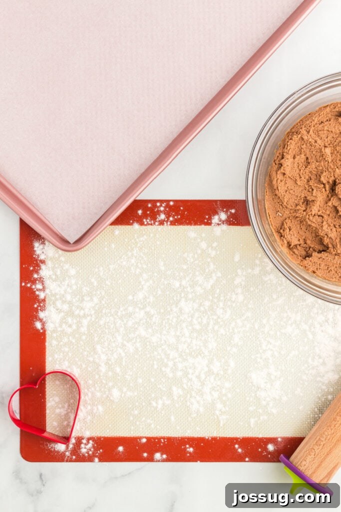 Floured silicone mat next to chocolate cookie dough.