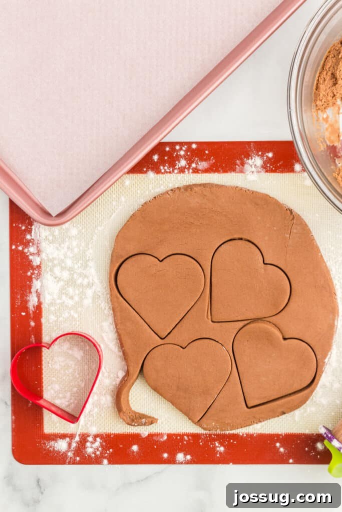 Rolled chocolate cookie dough with heart shapes cut out.