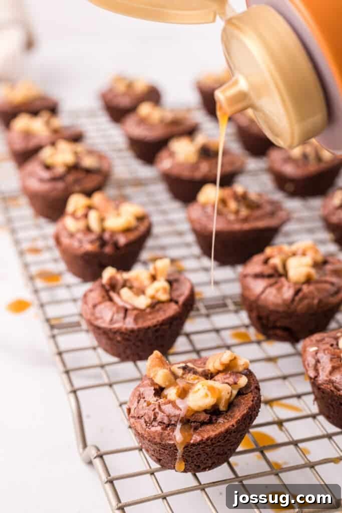 Close up of turtle brownie bites on a cooling rack while caramel is being drizzled over the tops.