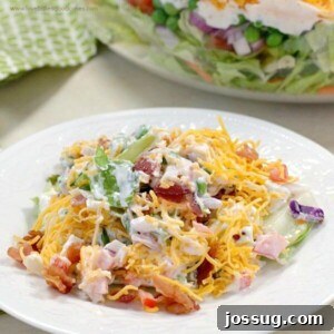 Delicious 7 Layer Salad, layered with fresh vegetables, cheese, and bacon