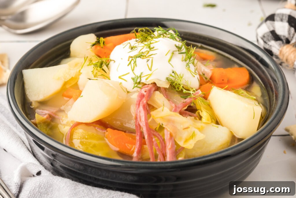 Hearty Corned Beef and Cabbage Soup 6 A black bowl filled with hearty corned beef and cabbage soup, with a spoon resting in it, showcasing its rich texture.
