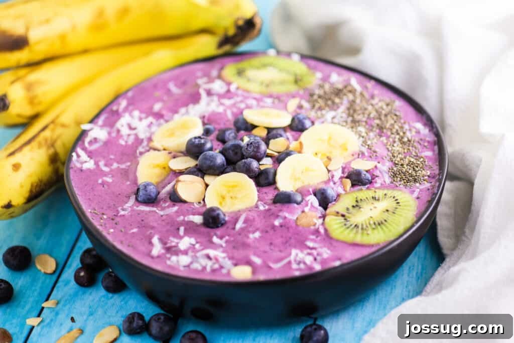 A fully garnished blueberry banana smoothie bowl in a decorative bowl, ready to be enjoyed.