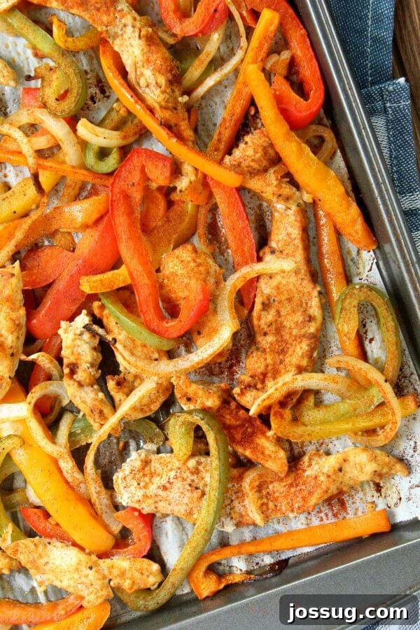 A close-up of Sheet Pan Chicken Fajitas, showcasing perfectly cooked chicken and colorful vegetables.