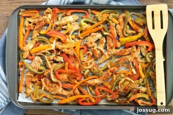 Sheet Pan Chicken Fajitas being served with a spatula, fresh from the oven.