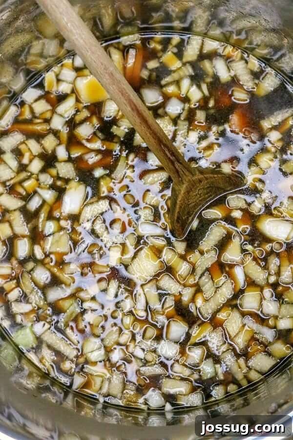 All Instant Pot Baked Beans ingredients thoroughly mixed in a large bowl with a wooden spoon, ready for pressure cooking.