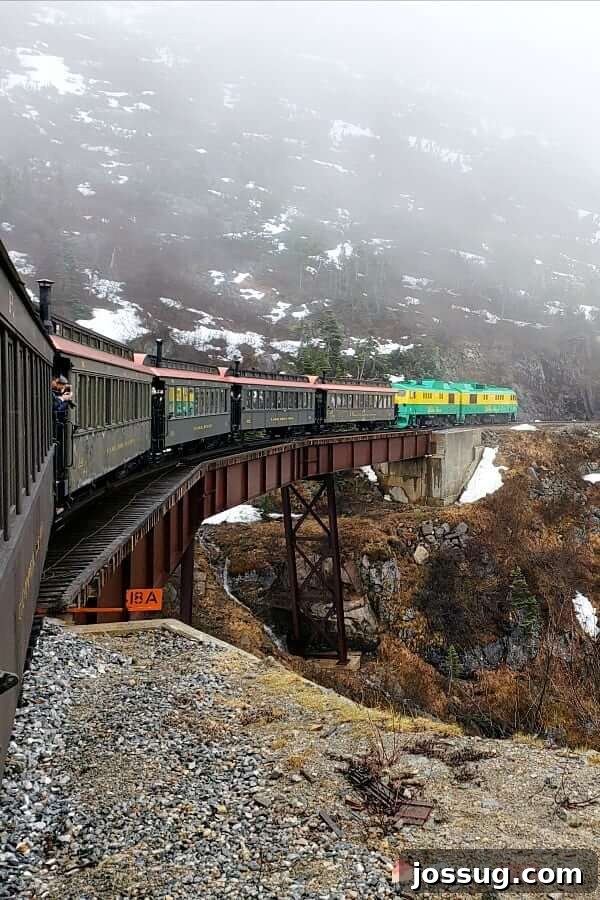 Smooth Sailing from the Start: Embarkation Day Essentials 14 Top Ten Must-Dos on Embarkation Day - White Pass Railway descending down the mountain over a trestle bridge with snow and fog.