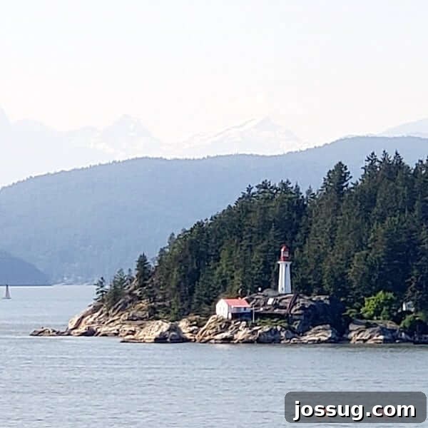 Smooth Sailing from the Start: Embarkation Day Essentials 6 A lighthouse sits on the bank of a body of water with tall trees behind it.