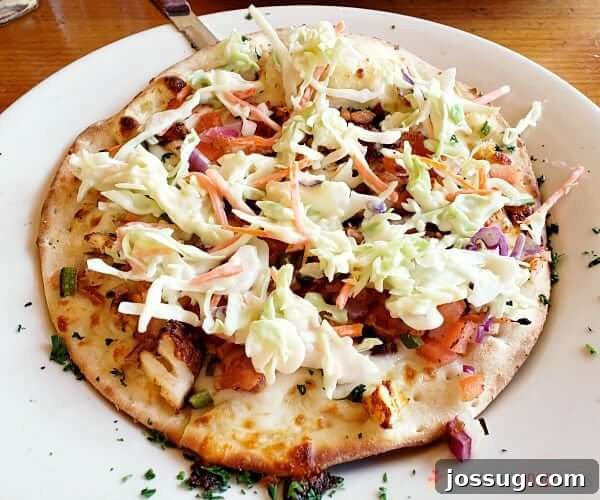 Fish taco pizza on a plate.
