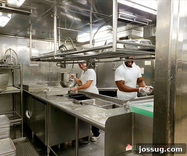 A meticulously organized area with dishwashers on a cruise ship, showcasing the efficiency of the kitchen operations.