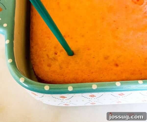 Tipsy Strawberry Margarita Poke Cake 3 Boozy Strawberry Margarita Poke Cake in a baking pan, fresh out of the oven.