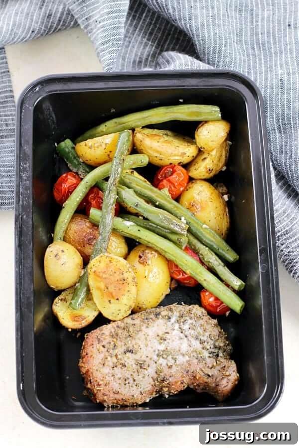 Italian Pork Chop Sheet Pan Dinner neatly portioned into a storage container, ready for meal prep or a grab-and-go meal.