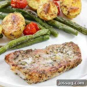 Italian Pork Chop Sheet Pan Dinner with seasoned pork, roasted potatoes, green beans, and tomatoes.
