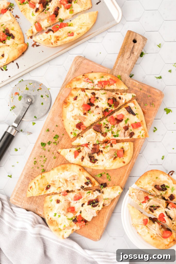 Delicious Chicken Bacon Ranch Naan Bread Pizza on a wooden pizza paddle, ready to be served.