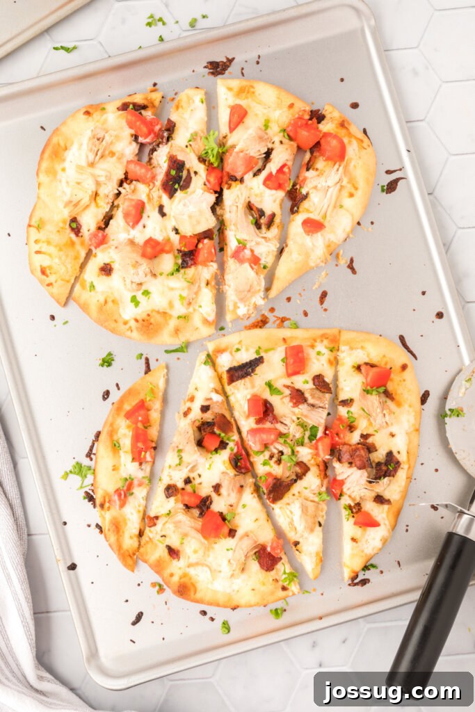 Chicken Bacon Ranch flatbread baking on a sheet pan, with melted cheese and crispy edges.