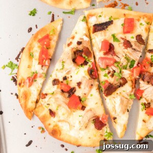 A top-down view of a delicious chicken bacon ranch pizza, perfectly sliced and ready to eat.