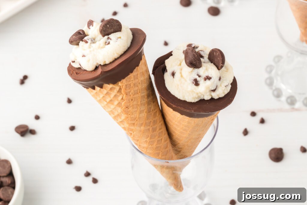 Cannoli Crunch Cones 5 Two cannoli cones held up in a glass, beautifully decorated and ready to be served.