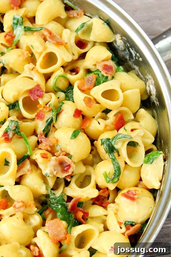 Effortless Creamy Bacon Spinach One-Pot Pasta 5 Close-up of One-Pot Creamy Bacon Spinach Pasta being stirred in a skillet, showing the rich texture.