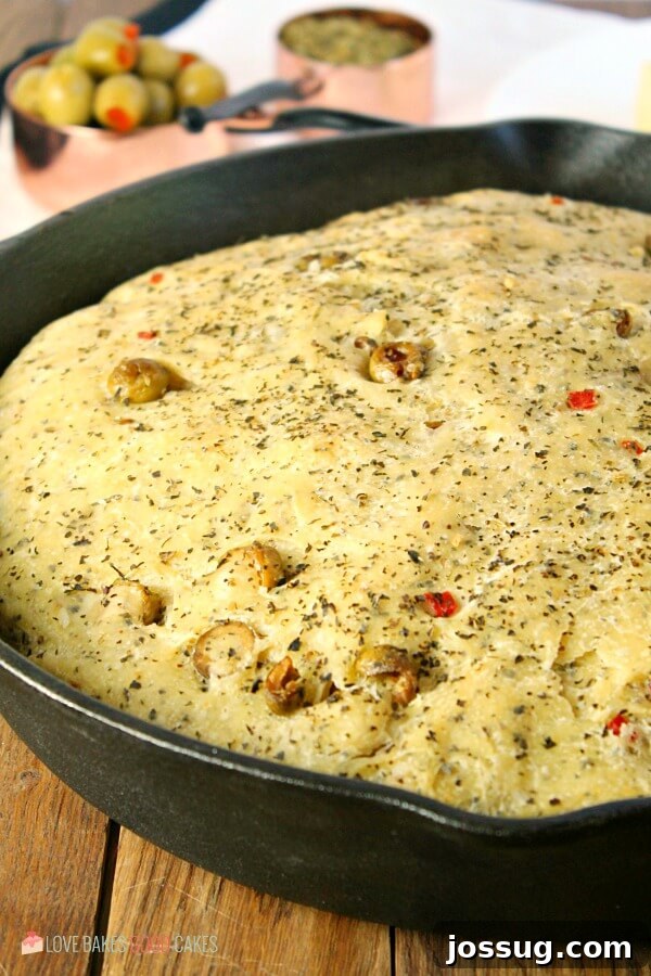 Freshly baked olive bread cooling in a cast iron skillet.