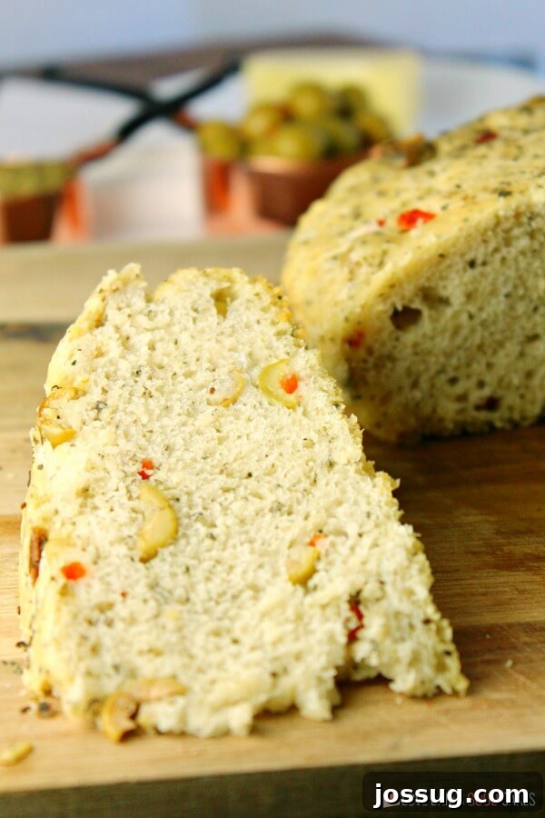 Close-up of sliced No-Knead Skillet Olive Bread revealing the airy crumb and embedded olives.