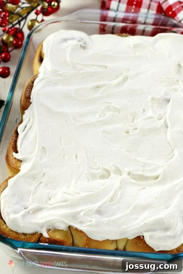 Festive Eggnog Cinnamon Rolls 3 A pan filled with freshly baked Eggnog Cinnamon Rolls, generously covered in a thick, luscious white eggnog cream cheese frosting, ready to be served and enjoyed by the family.
