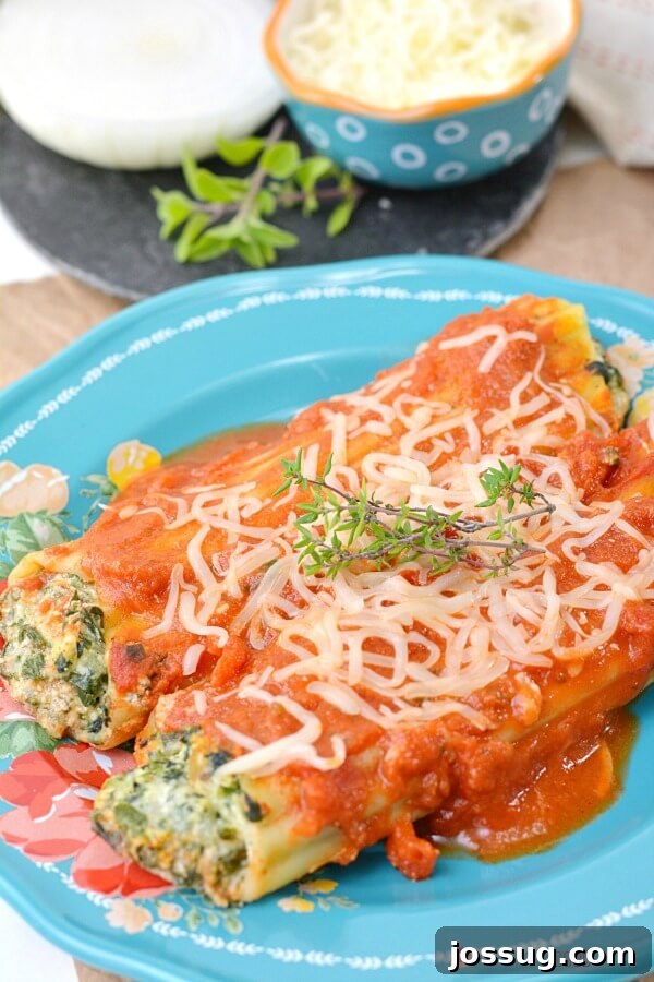 Two Spinach Ricotta Manicotti on a blue plate, ready to be served.