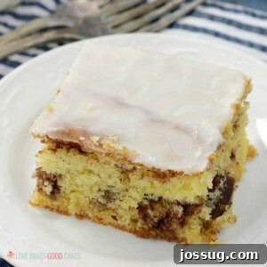A slice of Honey Bun Cake with cinnamon swirl and white glaze.