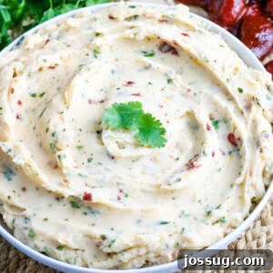 Close-up view of a bowl of fluffy Chipotle Cheddar Mashed Potatoes, highlighting the melted cheese and creamy texture.