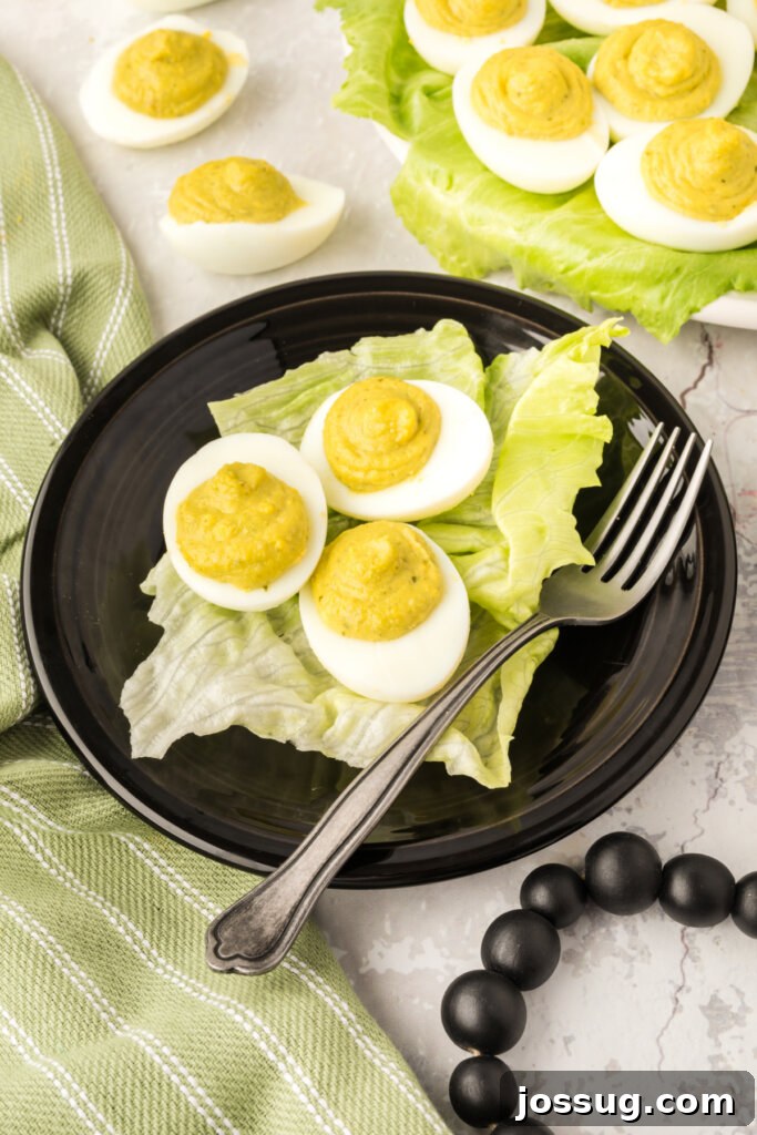 three pesto deviled eggs on black plate