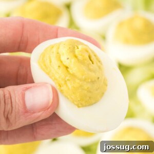 hand holding a pesto deviled egg