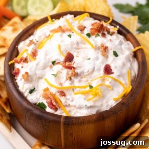 The Gourmet Gala Dip 7 A bowl of Million Dollar Dip, garnished with fresh parsley, surrounded by dippers.