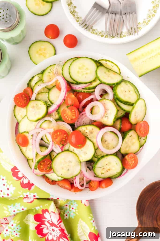 Vibrant Cucumber Tomato Medley 2 A vibrant Zesty Cucumber Tomato Salad served in a pristine white bowl, showcasing plump cherry tomatoes and perfectly sliced cucumbers, garnished with fresh dill.