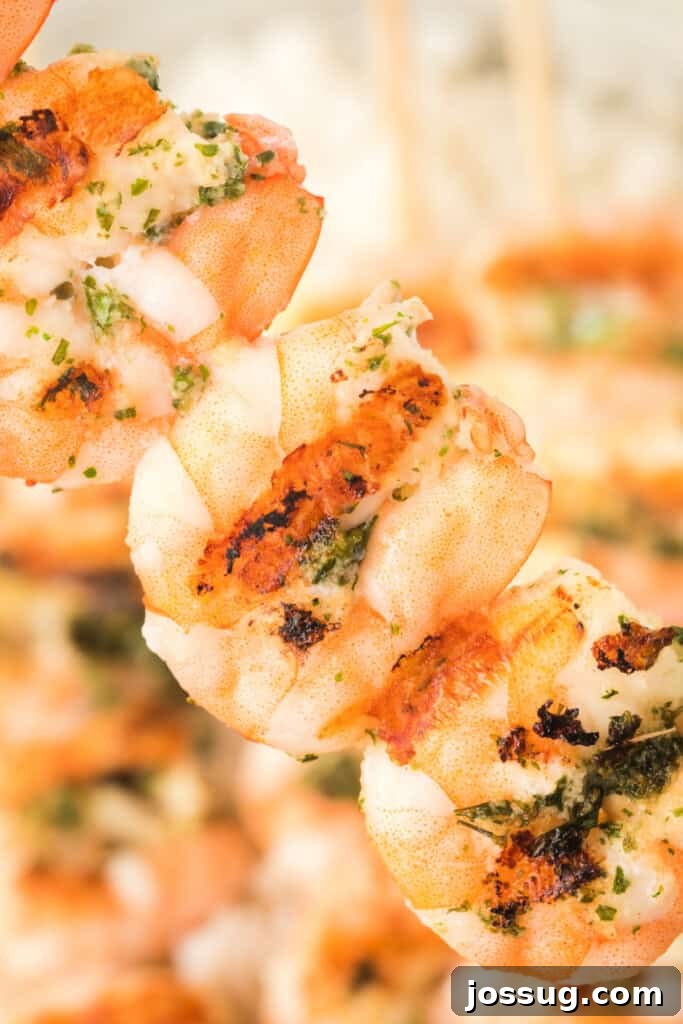 Extreme close-up of juicy grilled shrimp showing charred edges and fresh herbs, garnished with lemon wedges.
