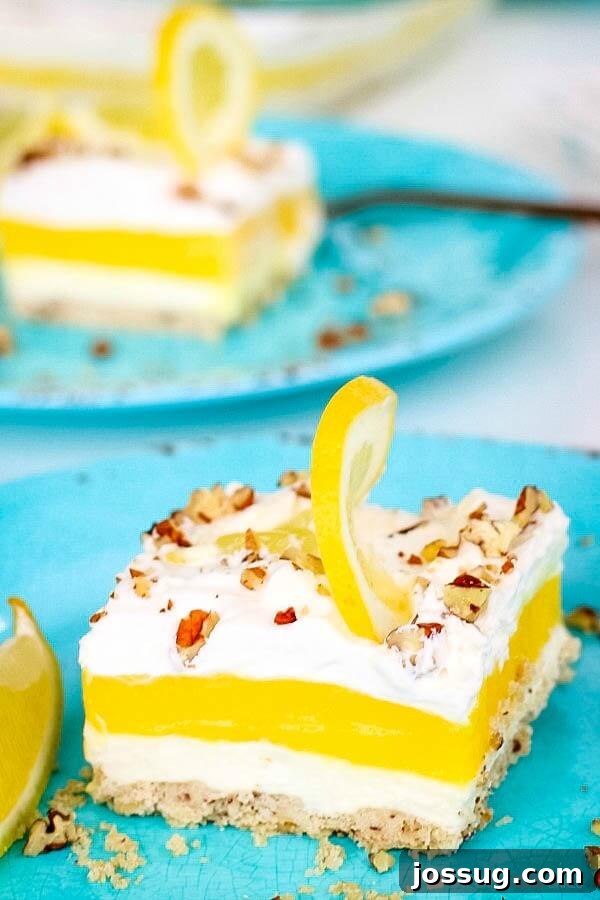 A close up of a piece of lemon lush delight pie on blue plates, showcasing its delicious layers.
