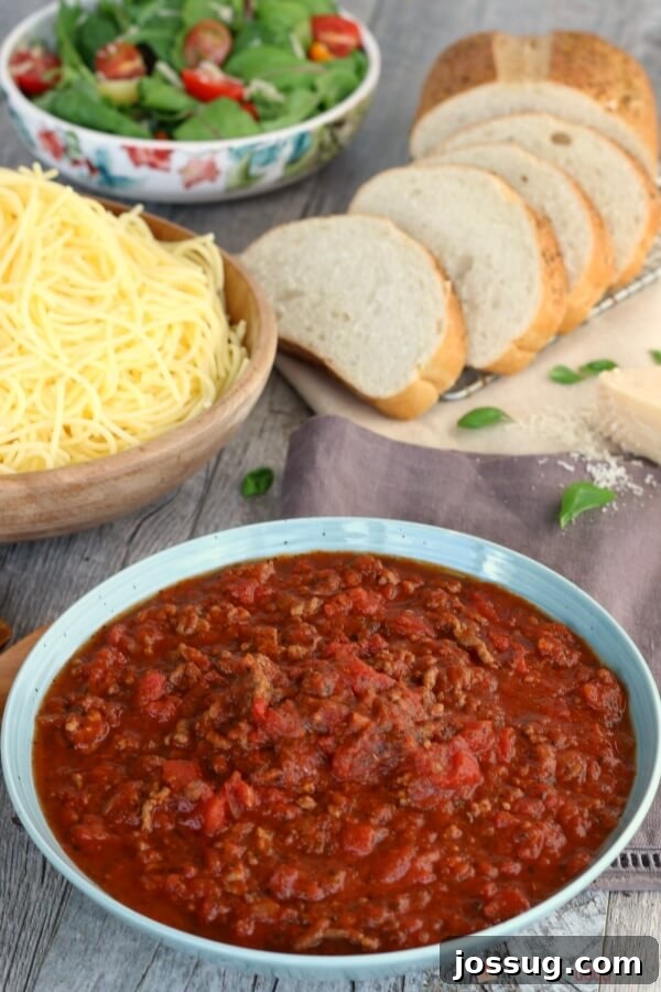 Slow Cooker Spaghetti Sauce and pasta with bread slices and a green salad.