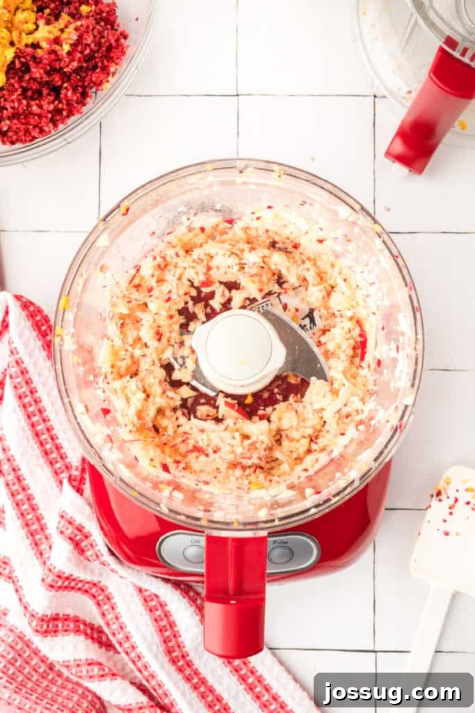 Cranberry Burst 11 Finely chopped apples inside the red food processor, creating a light, slightly chunky texture.