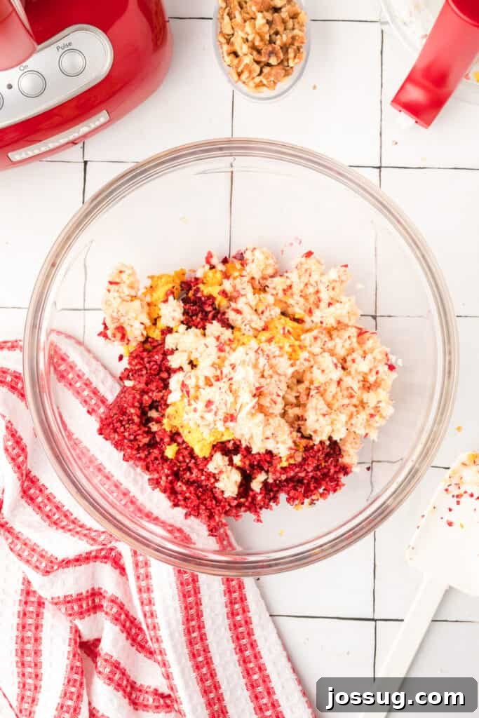 Cranberry Burst 12 Mixing bowl filled with chopped cranberries, oranges, and apples, ready for walnuts and sugar to be added to complete the relish mixture.