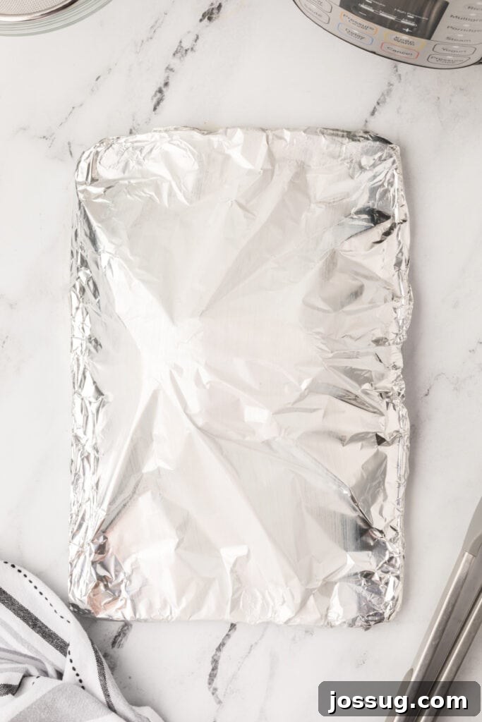 Baking sheet covered with foil, showing the turkey resting under foil to retain moisture.
