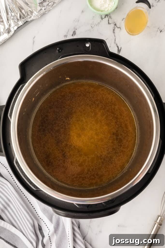 Turkey drippings simmering in the Instant Pot set to sauté mode, ready to be thickened for gravy.