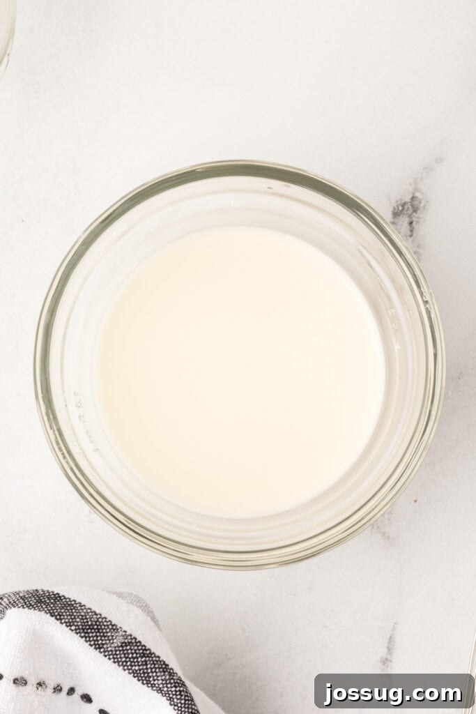 Smooth cornstarch slurry in a glass bowl, ready to be added to drippings for thickening.