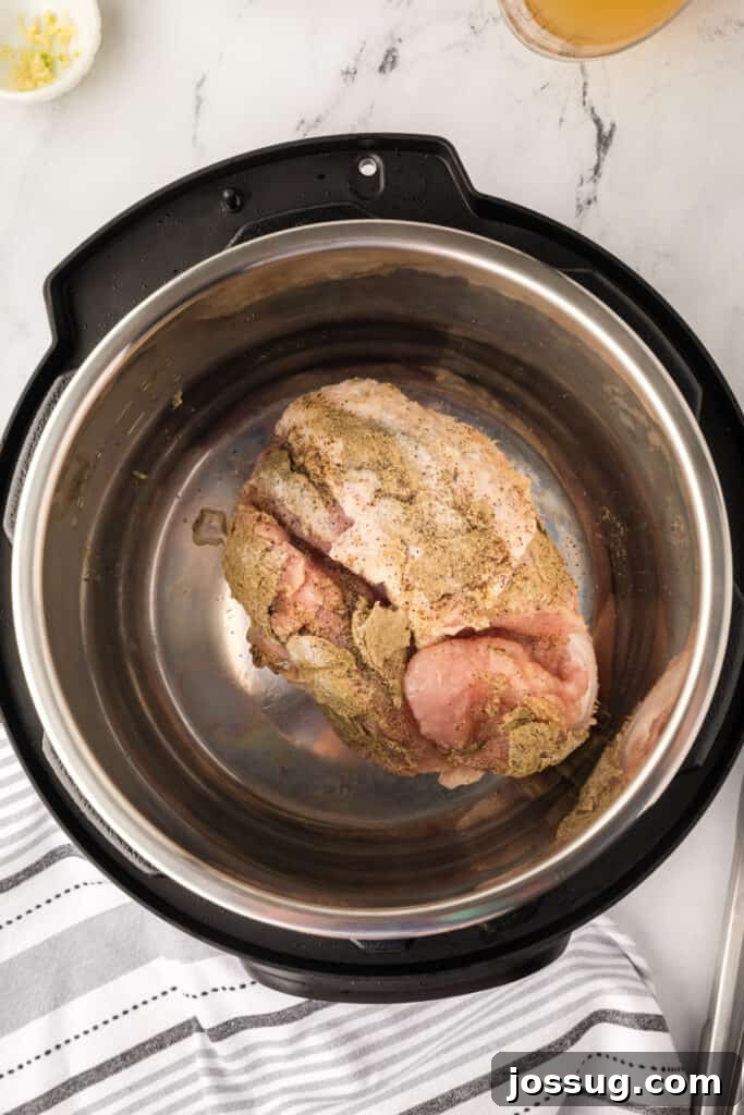 Turkey breast placed inside an Instant Pot inner pot, ready to sear on sauté mode.
