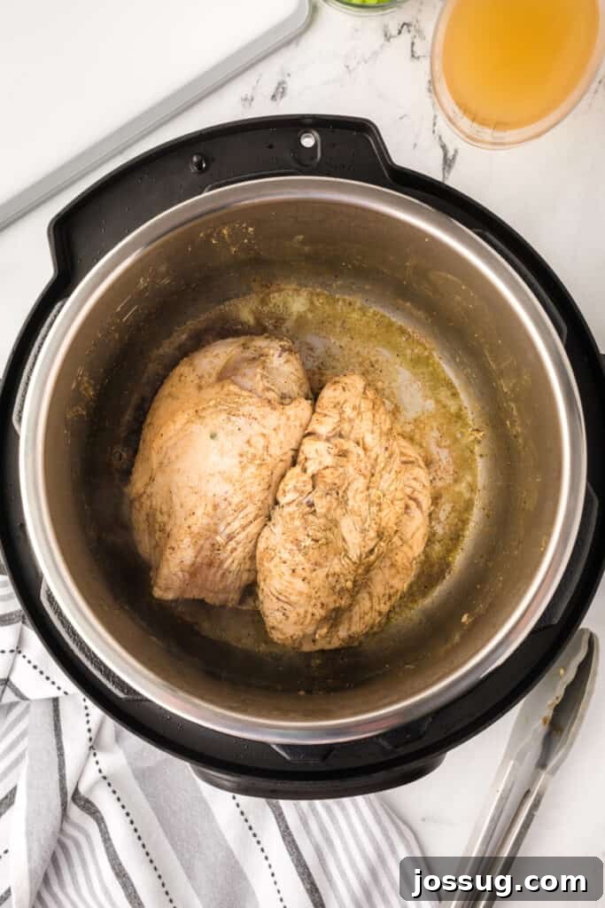 Seared turkey breast in Instant Pot showing golden brown color from sautéing.