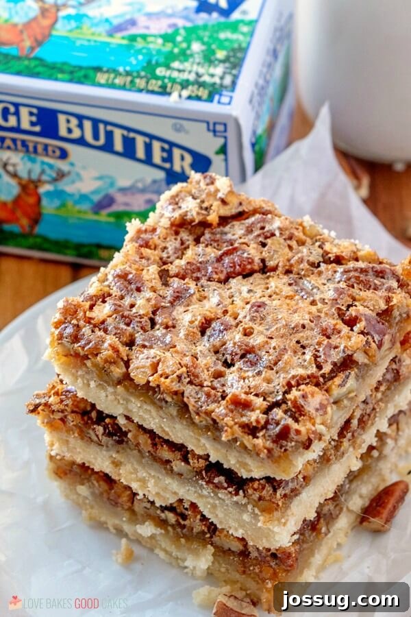 Skip the pie and make these Pecan Pie Bars! Shortbread topped with a gooey filling and crunchy pecans in an easy-to-eat with your hands' bar! Close up shot of Pecan Pie Bars with a package of Challenge Butter in the background