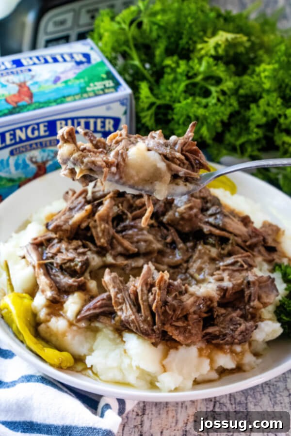 Forkful of tender shredded beef with mashed potatoes, poised for a bite