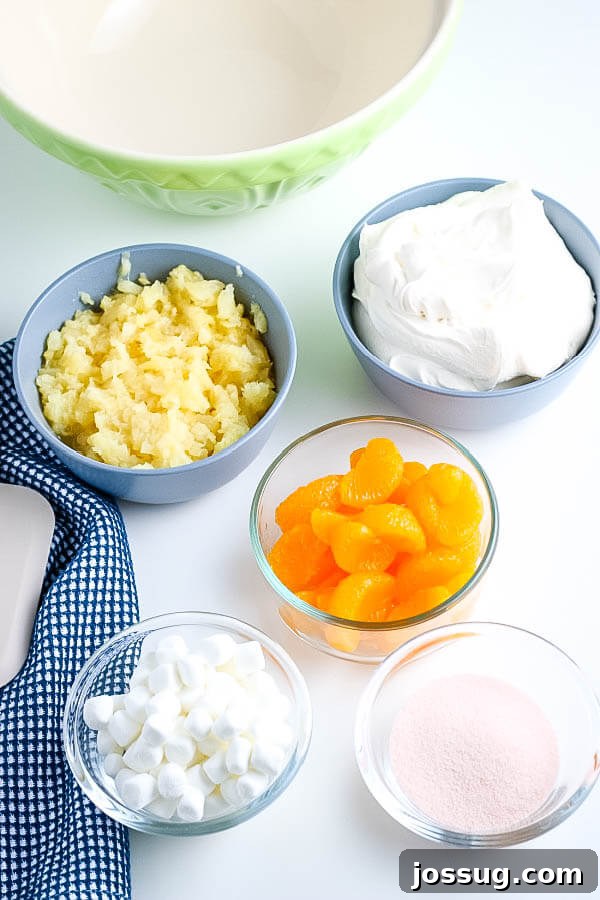 Creamsicle Dream Dessert 4 ingredients to make fruit salad, including whipped topping, orange jello, marshmallows, mandarin oranges, and crushed pineapple